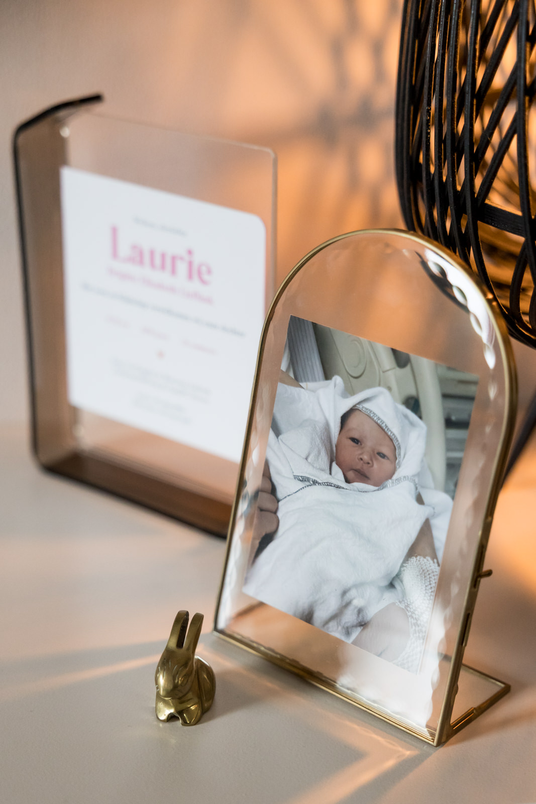 Detail van de eerste foto van Laurie na de geboorte naast haar geboortekaartje op het dressoir.